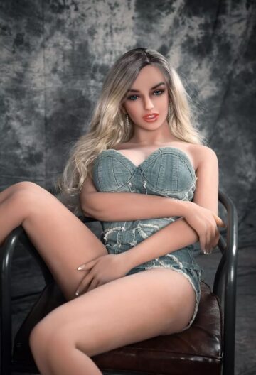 Секс-лялька Charlee сидить на стільці на сірому фоні